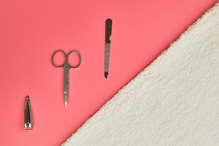 Manicure tools with white towel on pink background