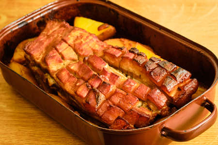 Tasty roasted pork belly with sliced potatoes in cooking panの写真素材