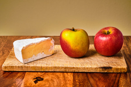 Still life with tasty fresh red apples and blue cheese on cutting board on wooden tableの写真素材