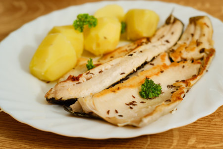 Tasty trout filets with boiled potatoes on white plateの写真素材