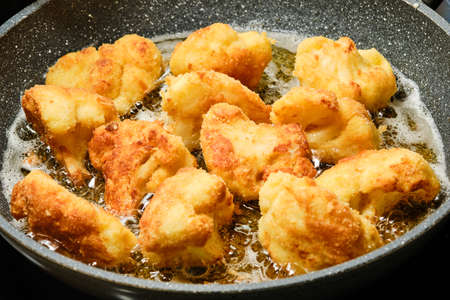 Cooking fried breaded cauliflower on frying panの写真素材