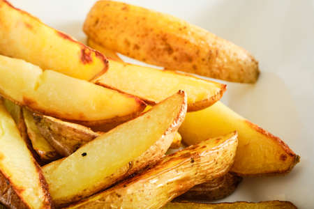 Tasty oven baked sliced potatoes in bowlの写真素材