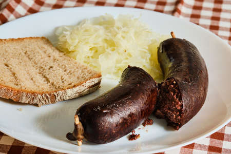 Tasty czech blood sausage gut with shredded cabbage and bread on plateの写真素材
