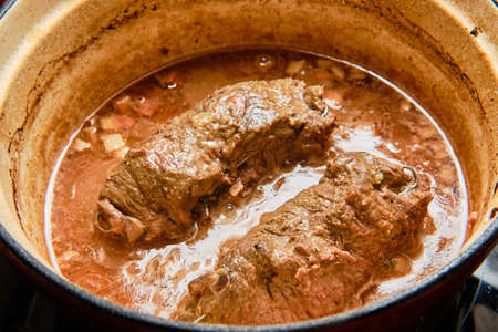 Preparing czech food stuffed beef meat with gravy spanelsky ptacek in cooking potの写真素材
