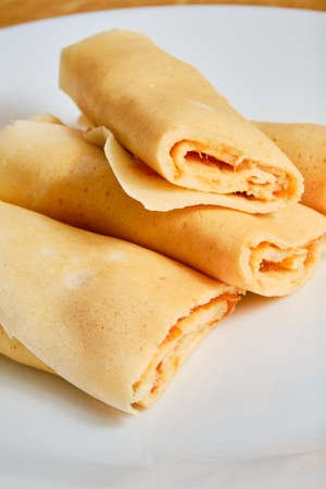 Tasty rolled crepes with apricot marmalade rolled on white plateの写真素材