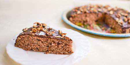 Tasty homemade walnut cake with chocolate piece on white plateの写真素材