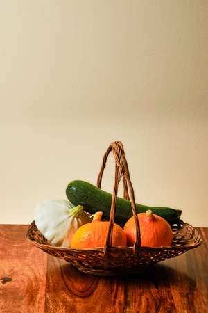 Summer vegetable still life with Hokkaido pumpkins, pattypan squash and zucchini in basketの写真素材