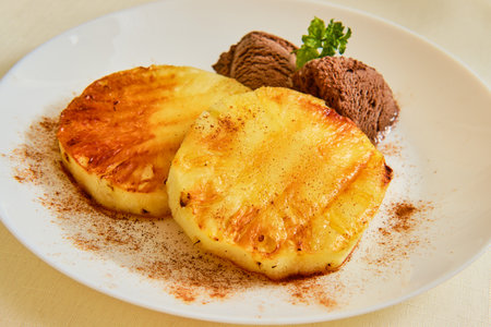 Tasty grilled pineapple with chocolate ice cream and mint on whiteの写真素材
