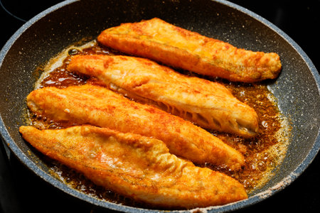 Preparing fried zander fish fillets on frying panの写真素材