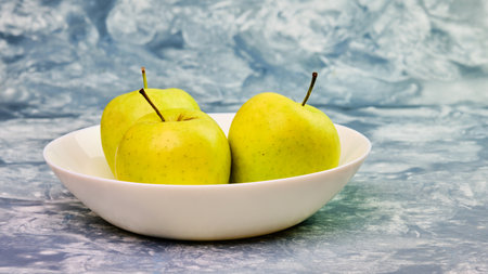 Tasty green apple fruit in white bowl still lifeの写真素材