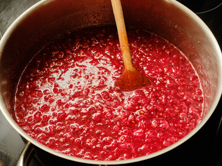 Cooking redcurrant berries in cooking pot preparing homemade jamの写真素材