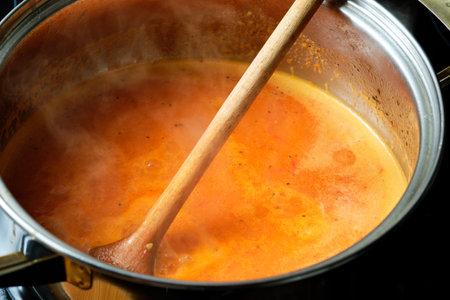 Mixed tomato soup in cooking pot preparing homemade soupの写真素材