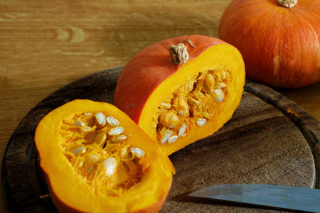 Sliced Hokkaido pumpkin in half on cutting boardの写真素材