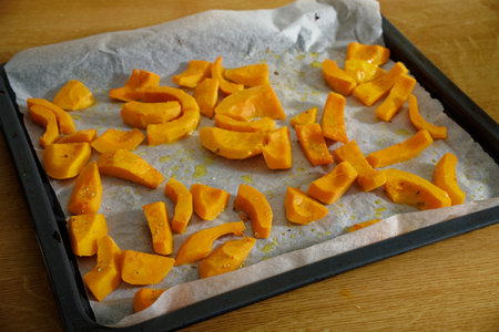 Tasty spiced sliced Hokkaido pumpkin on baking trayの写真素材
