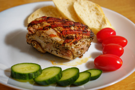 Tasty grilled pork tenderloin meat on a white plate with vegetablesの写真素材