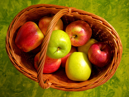 Fresh apple mix in basket on green background top viewの写真素材