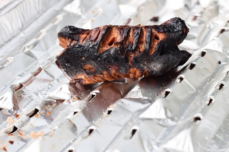 Detail of totally burnt sausage on tinfoil.の写真素材