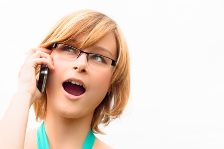 Surprised young business woman on phone, isolated on white background.の写真素材