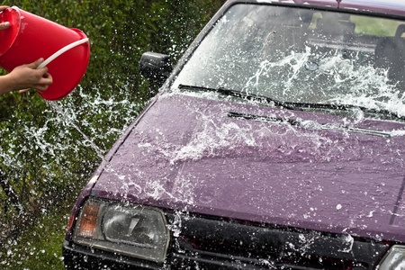 Quick car wash, pouring and spraying water from backet.の写真素材