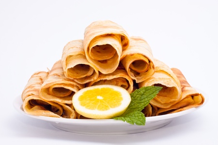 Delicious rolled crepes with lemon and mint, isolated on white background.の写真素材
