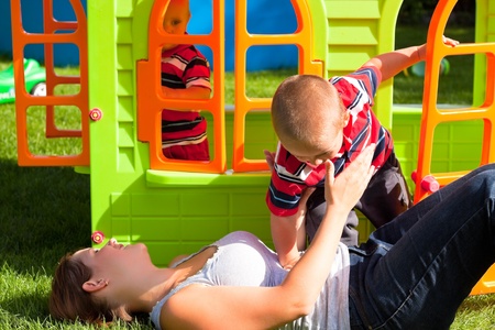Happy family and colorful playhouse. Mother and two little boys having fun in the garden.の写真素材