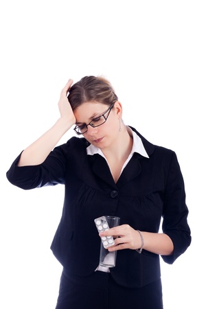Portrait of young woman with headache, holding glass with water and painkillers. Isolated on white background.の写真素材