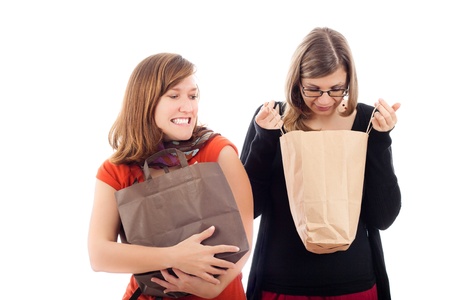 Shopping madness concept, two young excited women shopping, isolated on white background.の写真素材