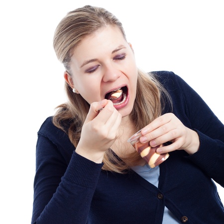 Young woman eating delicious sweet creamy dessert, isolated on white background.の写真素材