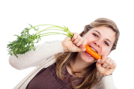 Young beautiful funny woman biting fresh carrot, isolated on white background.の写真素材