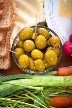Close up of table with fresh green olives and vegetable.の写真素材