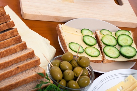 Detail of kitchen table and preparation of healthy vegetarian sandwiches with cheese.の写真素材