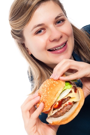 Young happy beautiful woman holding fresh hamburger, isolated on white background.の写真素材