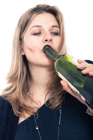Portrait of drunk woman drinking bottle of wine, isolated on white background.の写真素材