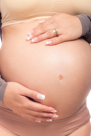 Close up of beautiful pregnant woman holding her belly.の写真素材