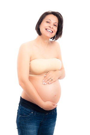 Happy beautiful pregnant woman laughing and holding her belly, isolated on white background.の写真素材