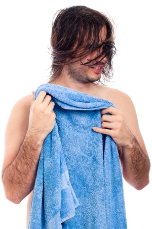Young man after bath going to dry his long hair with blue towel, isolated on white background.の写真素材