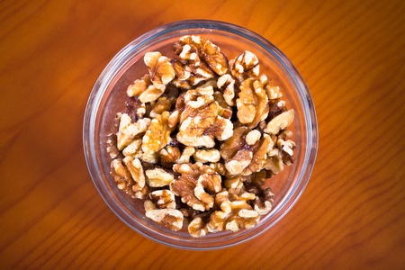 Close up of bowl with walnuts on brown wooden table.の写真素材