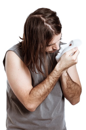 Bizarre psycho artist man holding mask, isolated on white background.の写真素材