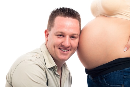 Happy smiling expectant father listening pregnant woman belly, isolated on white background.の写真素材