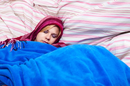Young woman sleeping wrapped in a duvet.の写真素材