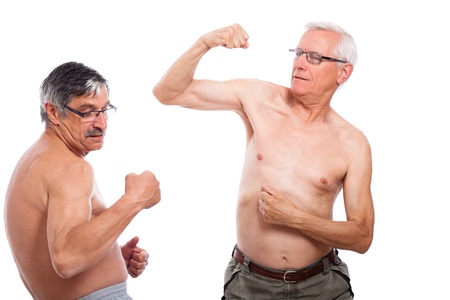 Two happy naked senior men comparing muscles, isolated on white background.の写真素材