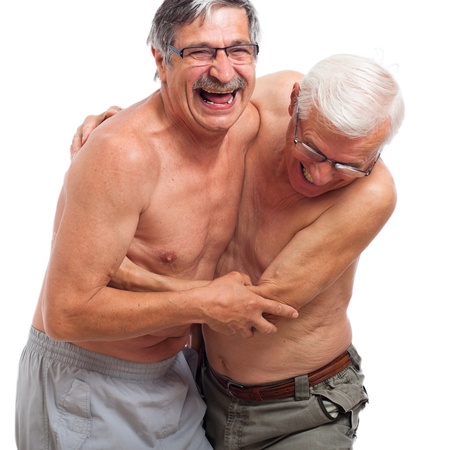 Two naked seniors laughing and fighting for fun, isolated on white background.の写真素材