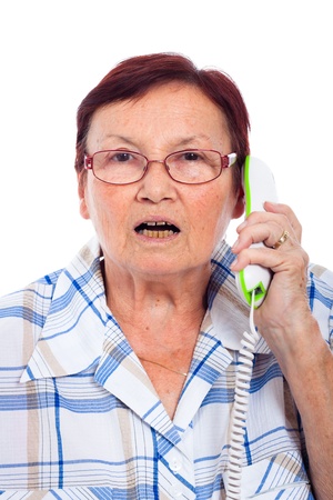 Close up of shocked senior woman on the phone, isolated on white background.の写真素材