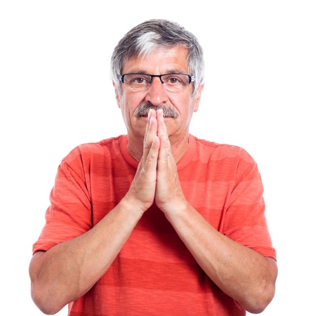 Serious senior man praying, isolated on white background.の写真素材
