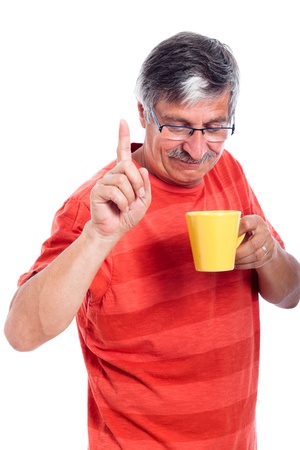 Senior man holding mug and gesturing, isolated on white background.の写真素材