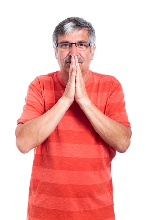 Portrait of pensive senior man praying, isolated on white background.の写真素材