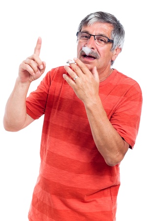 Senior man smoking cigarette and gesturing, isolated on white background.の写真素材