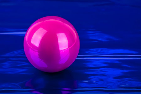 Pink Christmas ball over shiny blue background.の写真素材