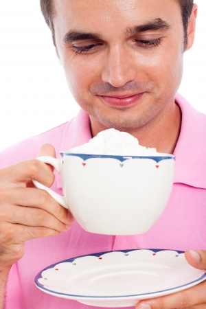 Close up of smiling man holding cup of coffee with whipped cream.の写真素材