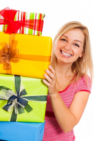 Young attractive blond happy woman and stack of colorful gift boxes, isolated on white background.の写真素材
